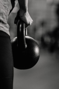 Person holding kettlebell in black and white